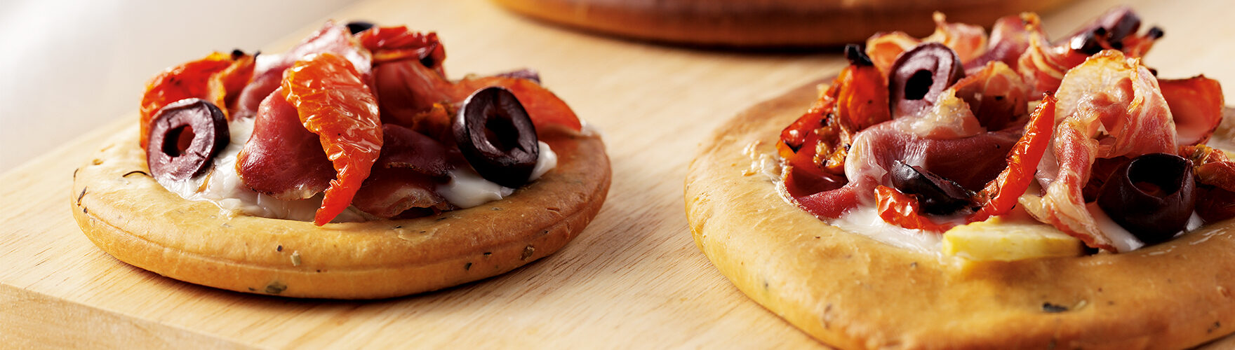 Pizza au fromage de chèvre, au jambon de Parme et aux olives fraîches