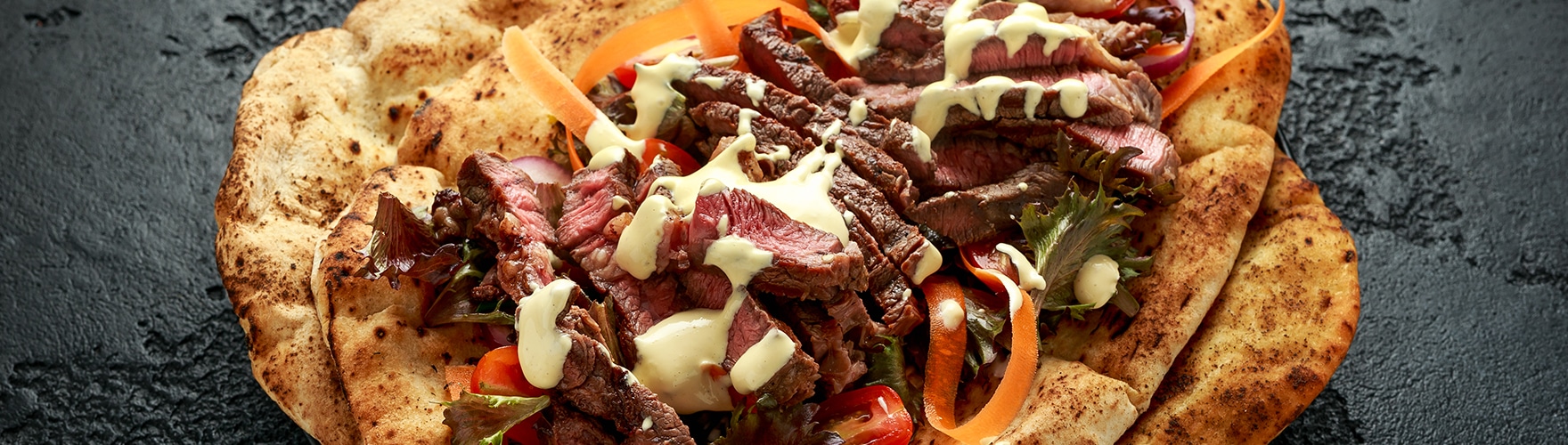 Naan bread with beef strips and a topping of extra mature cheese