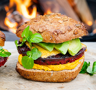 Hamburguer de beterraba com queijo cheddar, abacate, húmus e agrião.