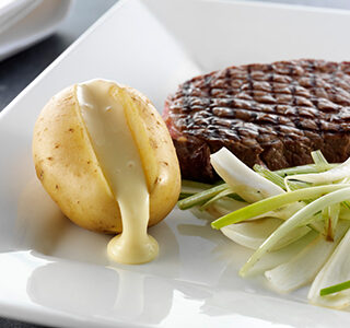 Grilled prime rib served with potatoes filled with ERU Spreadable Gouda, and braised fennel