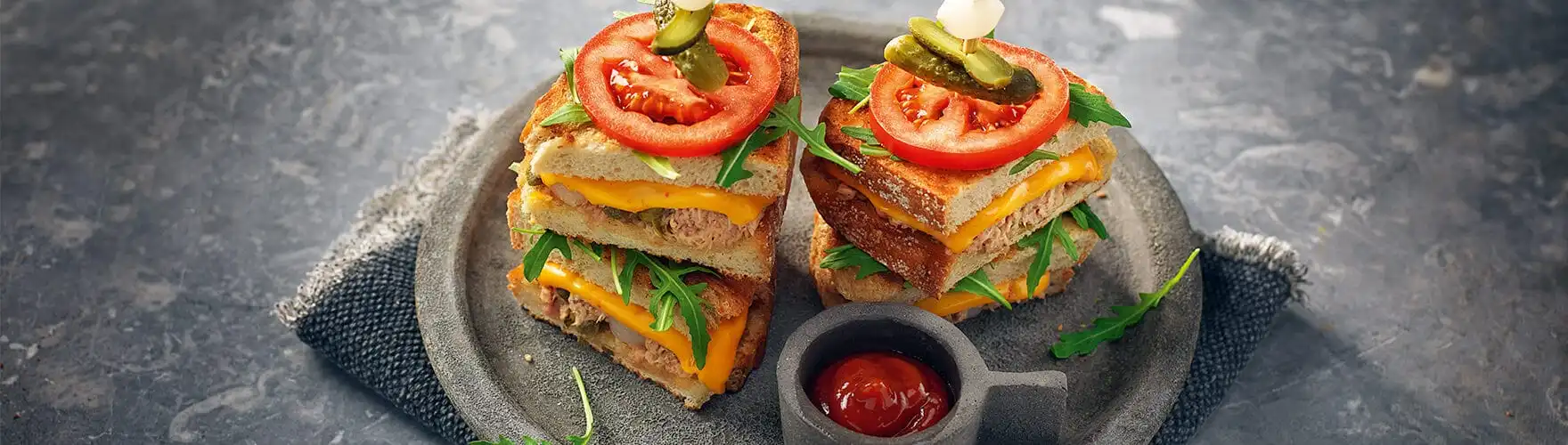 Pantosti met cheddar, tonijn, sambal, kappertjes, augurk en tomaat