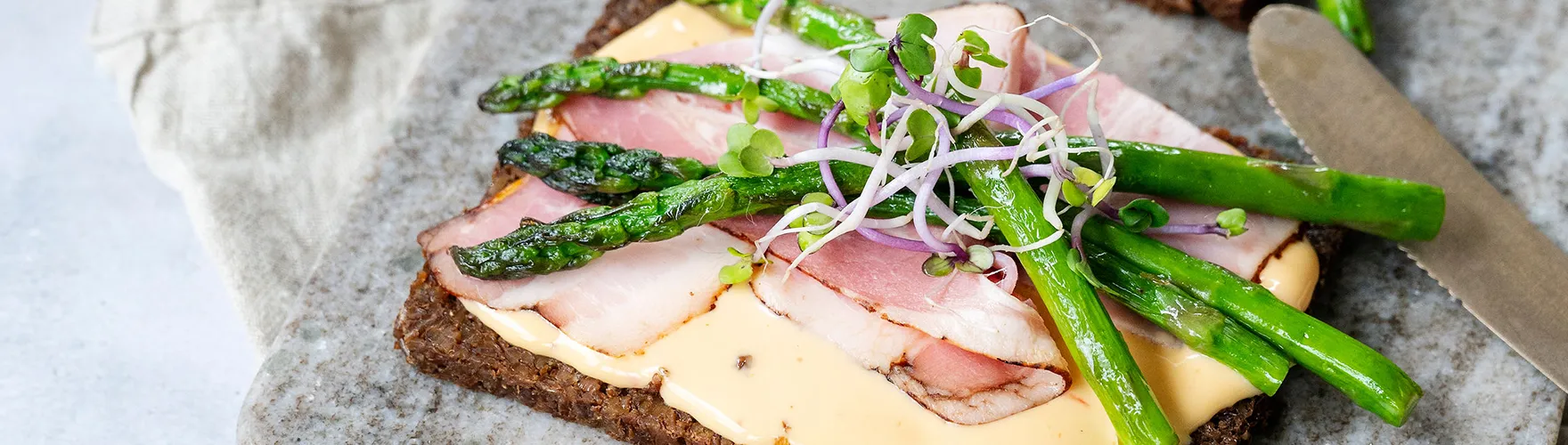 Roggebrood met katenspek, gegrilde groene asperges en kiemgroenten