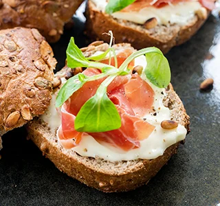 Pompoenbroodje met serranoham, veldsla en pijnboompitten