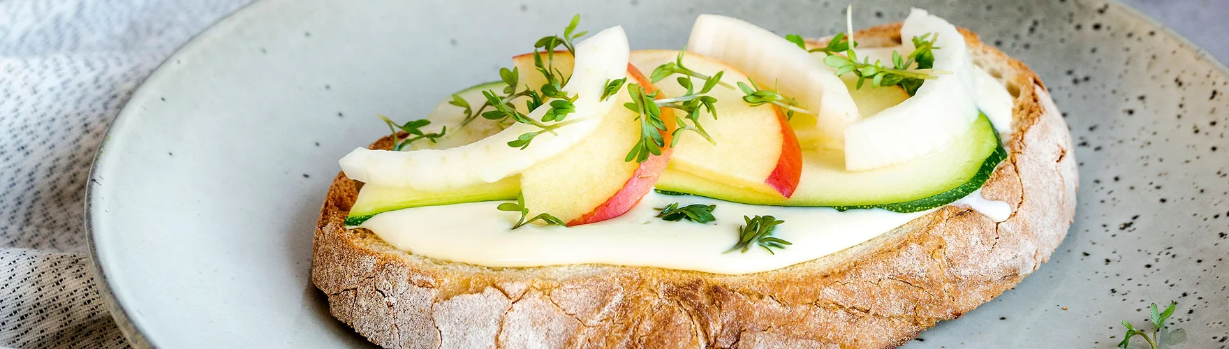 Rustieke boterham met roomzachte smeerkaas, courgette, appel, venkel en tuinkers