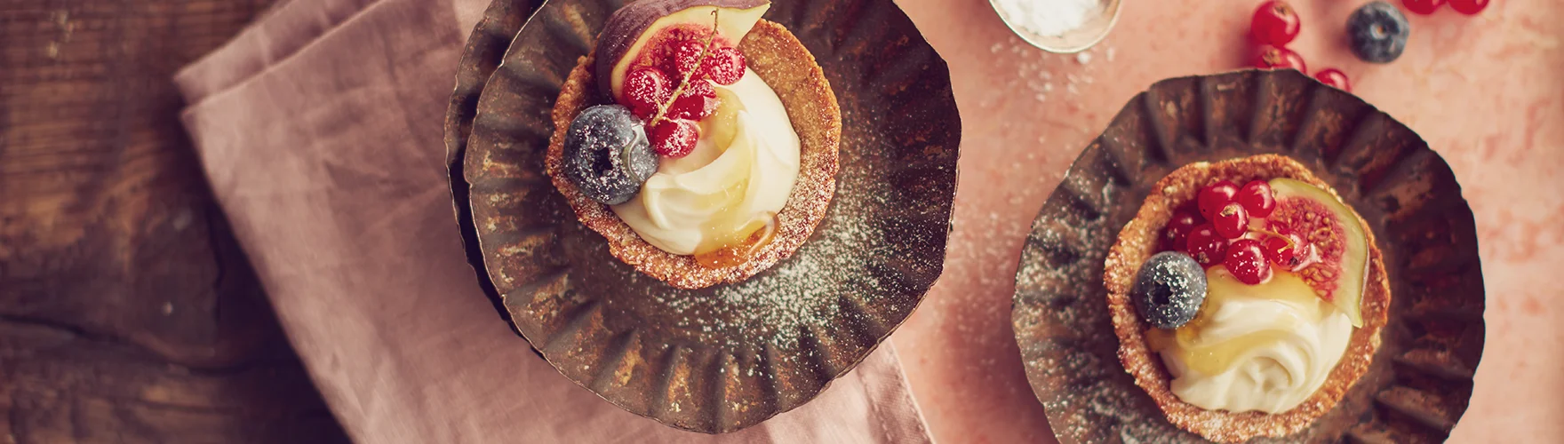 Granola taartjes met een mengsel van geitenkaas, vers fruit en honing