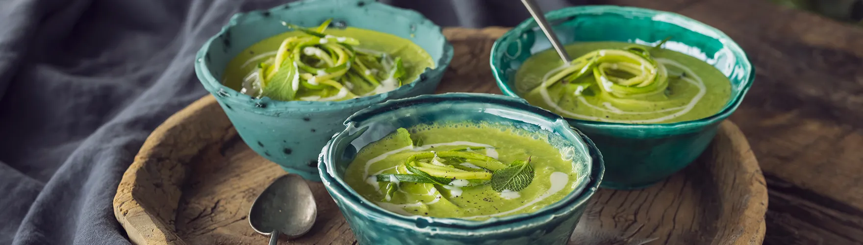 Lentesoep van courgette en lente-ui met een swirl van blauwe kaas