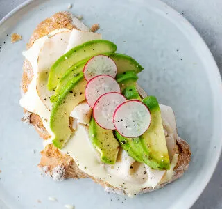 Zuurdesembrood met biologische kaas, kipfilet, avocado en radijs