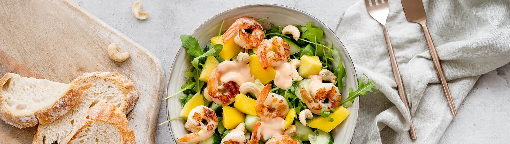 Salade met garnalen, rucola, mango, komkommer, cashewnoten en pittige kaas