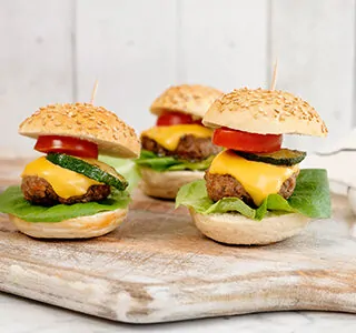 Mini hamburgers met plakjes cheddar, sla, cherrytomaten en gegrilde courgette