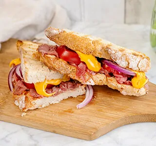 Tosti met pittige plakjes cheddar, rosbief, tomaten en rode ui